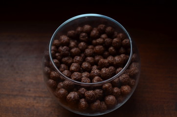 Breakfast. Chocolate balls from cocoa in a beautiful transparent glass on a dark background.