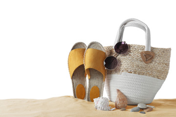 Composition with beach objects on sand against white background, space for text