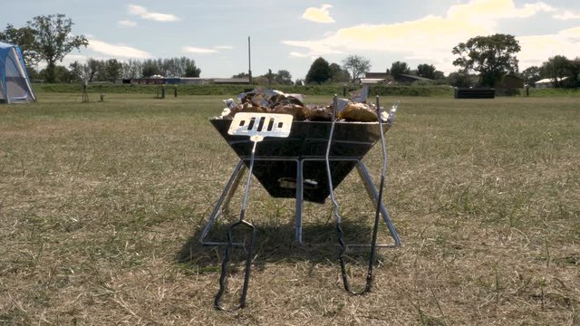 portable barbecue grill on green lawn. picnic or summer camping trip