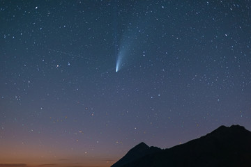 comet Neowise twin tails glowing in the night sky. Telephoto view, details of the two star trails....