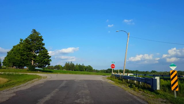 Driving Turning Around Road Bend Corner Approaching Rural Stop Sign, Stopping, and Turning Right. Driver Point of View POV Driver Approach Road Sign and Turns.