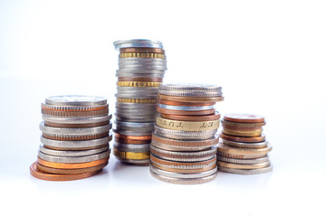 Coins on a white background. Money from different countries is in the pile. Pyramid of coins. Concept - small savings. Concept - the accumulation of money. Lack of money in accounts.