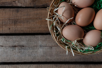 Eggs in basket on wooden background