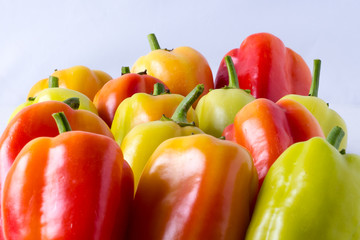 Red yellow and green pepper on a tray, side view