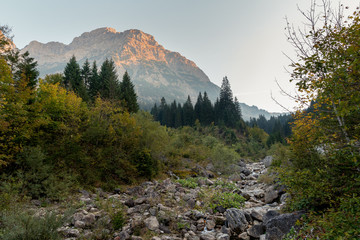 Sunset in Austria, State Vorarlberg with the mountain Widderstein in the background and  a stream in the foreground.
