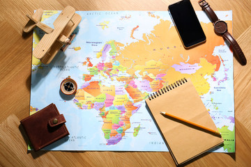 Fototapeta na wymiar Flat lay composition with world map and different items on wooden background. Trip planning