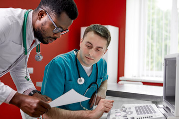 veterinary surgeons are examining an x-ray of a dog looking at paper, discussing solutions to the...