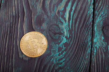 Gold bitcoin on painted pine boards.