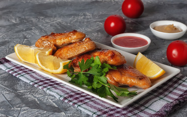 Grilled chicken wings with tomatoes, lemons and parsley