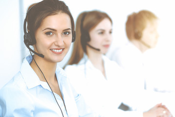 Call center. Focus on beautiful business woman in headset