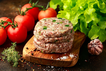 butcher made raw minced duck meat hamburger patties on wooden board ready to cook
