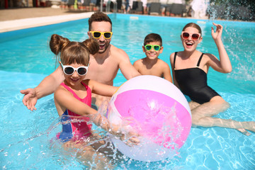 Happy family having fun in swimming pool