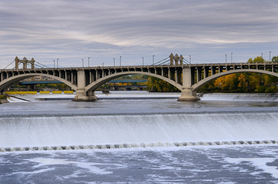 St Anthony Falls on the Mississippi river in Minneapolis with the Third Avenue bridge and wave clouds