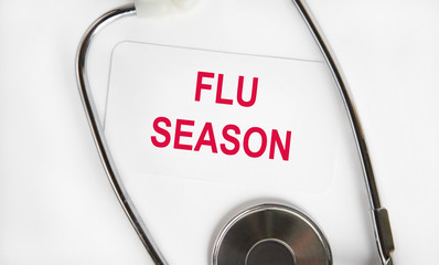 On the card is the inscription in red letters FLU SEASON, next to the stethoscope. Medical concept.