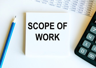 Scope of work. inscription on a white business card against the background of financial charts of a pencil and money. BUSINESS CONEPT