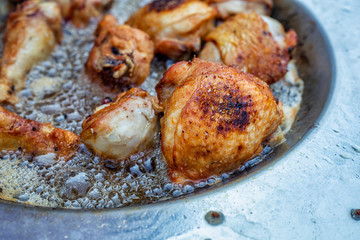 Chicken thigh frying in hot oil dish plate