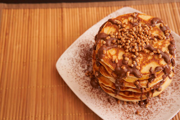 Delicious plate of pancakes with peanut syrup, cocoa and toppings