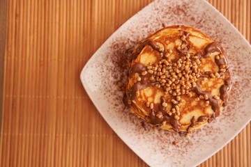 Delicious plate of pancakes with peanut syrup, cocoa and toppings
