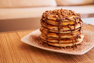 Delicious plate of pancakes with peanut syrup, cocoa and toppings