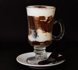 "Submarino" typical  drink from Argentina. Hot milk with a piece of chocolate, in a black background.