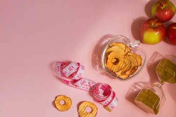 Organic apple chips, cinnamon and star anise on a pink background. Healthy vegan vegetarian fruit snacks. Natural food for wellness. Time to lose weight
