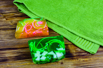 Pieces of the handmade soap and towel on wooden background