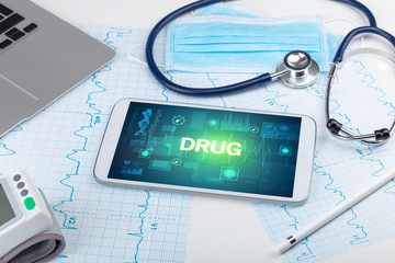 Tablet pc and medical stuff with DRUG inscription, prevention concept