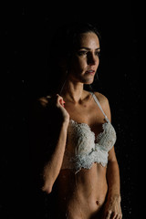 Young woman with gorgeos sport body in white lingerie with water drops in aquastudio