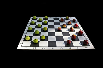 Red and green apples on the checkers Board on a black background