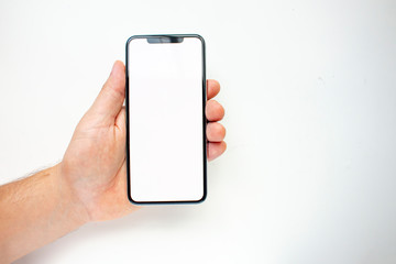 A person holding an Smart Phone with a white screen on a white background.