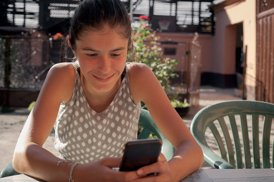  young girl communicates on a smartphone with a smile