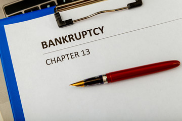 Bankruptcy petition at the table and pen