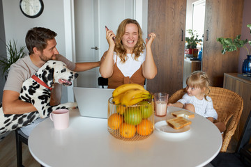 woman is tired of the noise, no free time for herself, sit with husband, daughter and dog in the kitchen