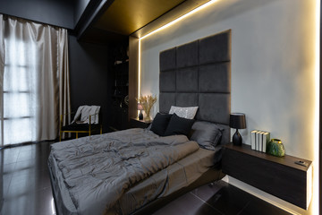 Fototapeta na wymiar dark modern stylish male apartment interior with lighting, decorative walls, fireplace, dressing area and huge window