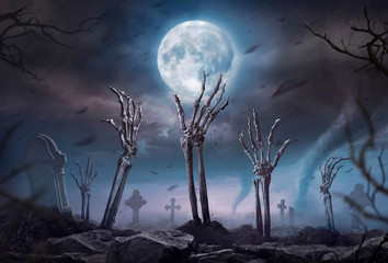 Zombie skeleton hand rising in dark Halloween night.