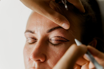 Blepharoplasty markup close-up on the face before the plastic surgery operation for modifying the...