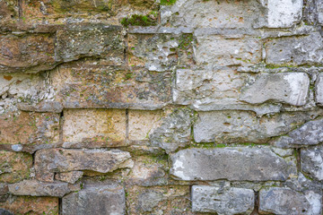 Embossed textured surface of an old wall made of facade bricks and cement
