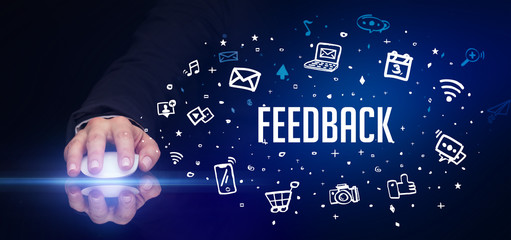 hand holding wireless peripheral with FEEDBACK inscription, social media concept