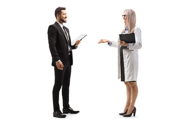 Full length profile shot of a female doctor talking to a professional man in a black suit