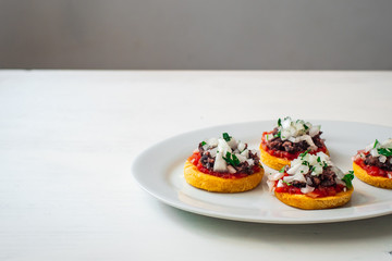 Sopes also known as Picadita, Traditional Mexican Dish That Looks like an Unusually Thick Tortilla with Toppings like Tomato Sauce, Refried Beans, Raw Onion, Cilantro