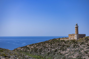 Fototapeta na wymiar View of Mediterranean Sea with lighthouse from Belvedere di Capo Sandalo, Carloforte, Sardinia, Italy