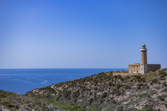 View of Mediterranean Sea with lighthouse from Belvedere di Capo Sandalo, Carloforte, Sardinia, Italy