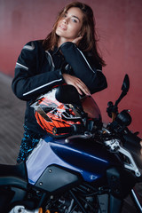 Fototapeta na wymiar Love of biker and his custom modern vehicle. Urban motorbike hobby. Beaty girl with her bike on the bridge.