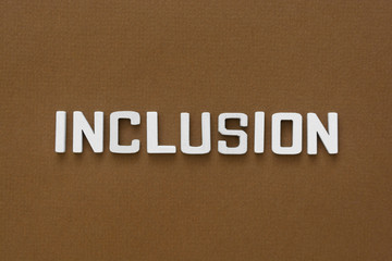 Inclusion word on brown background.Equality, discrimination and integration concept.