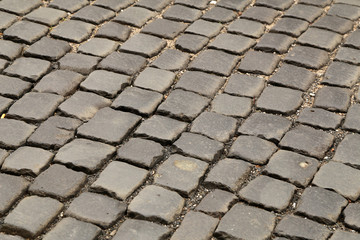 Fototapeta premium Abstract background of old cobblestone pavement close-up