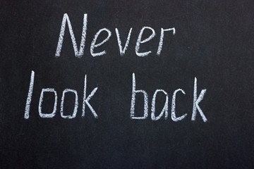 
Writing on the black board "never look back." Motivating inscription