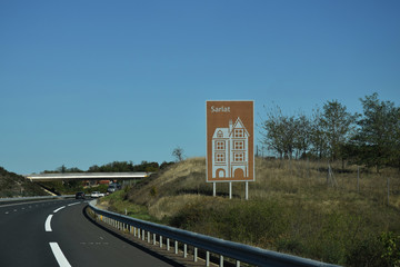 En roulant : panneau touristique sur autoroute A20. Sarlat, Dordogne, Nouvelle-Aquitaine, France.
