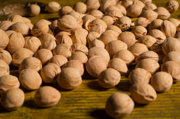 close up of dried chickpeas on a wooden table. dried legumes such as chickpeas are suitable for filling a very soft pillow: they adapt perfectly to the head and neck.
