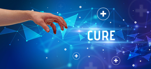 Close-Up of cropped hand pointing at CURE inscription, medical concept