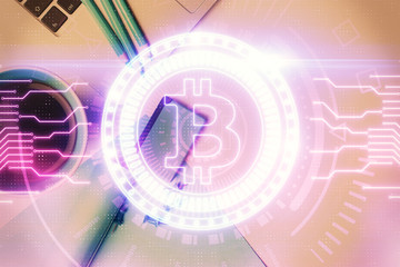 Obraz premium Blockchain theme hologram drawings over computer on the desktop background. Top view. Multi exposure. Concept of cryptoeconomy.